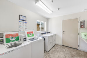 laundry room with 4 machines and window